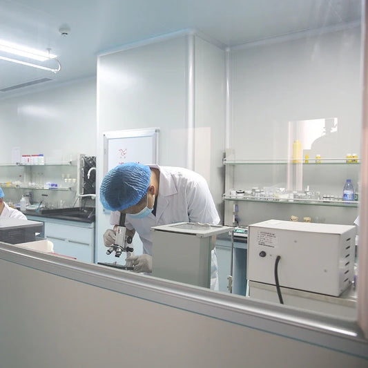Scientist conducting laboratory testing with a microscope to assess tattoo ink quality and safety. 