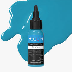 A 1 fl oz bottle of NECOH Tattoo Ink in the shade Blue Sky, shown with a black cap and surrounded by blue liquid splashes on a light gray background.