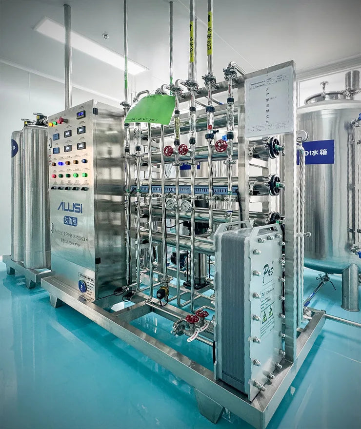 A large stainless steel water purification system with multiple connected tanks, pipes, valves, and control panels, photographed inside a clean industrial room with bright blue flooring.