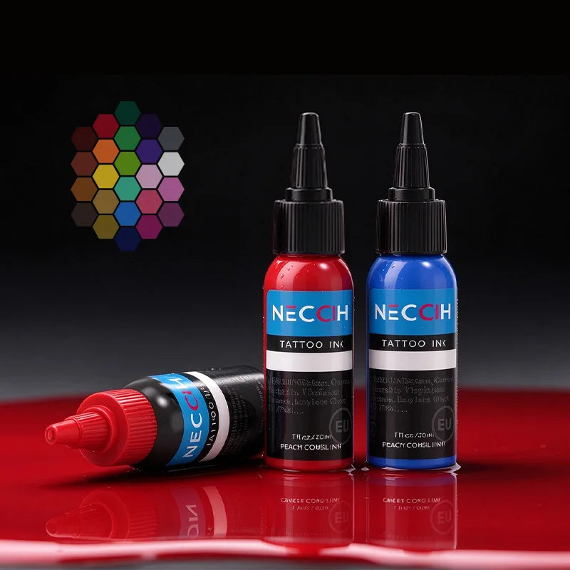 Three NECCIH Tattoo Ink bottles on a glossy red surface against a black background, including one red bottle standing upright, one blue bottle standing upright, and one black bottle lying on its side. A small multicolor hexagon color wheel graphic appears in the upper left.